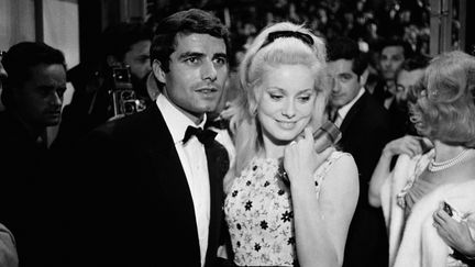 L'acteur italien Nino Castelnuovo et l'actrice française Catherine Deneuve à la présentation du film "Les parapluies de Cherbourg" de Jacques Demy, au festival de Cannes (France) le 29 avril 1964. (REPORTERS ASSOCIES / GAMMA-RAPHO / GETTY)