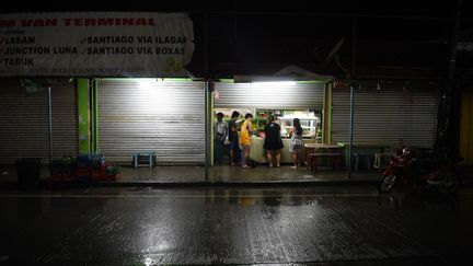 Des haitants de&nbsp;Tuguegarao, au nord de Manille (Philippines) achètent de quoi manger dans un restaurant, le 14 septembre 2018, à l'approche du typhon Mangkhut. (TED ALJIBE / AFP)