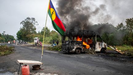 Un drapeau kanak près d'un véhicule en feu le 19 mai 2024. (DELPHINE MAYEUR / AFP)