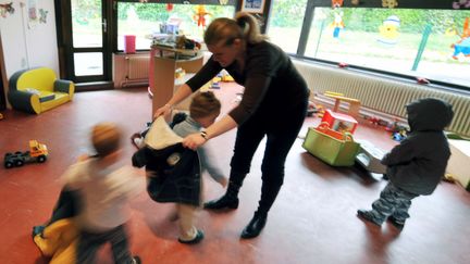 Une assistante maternelle accueille des enfants dans un crèche collective d'Hérouville Saint-Clair dans le Calvados. (MYCHELE DANIAU / ARCHIVES)