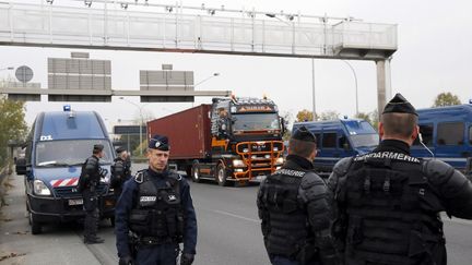 Intervention des forces de l'ordre pendant une op&eacute;ration escargot de camions contre l'&eacute;cotaxe au niveau du portique de Rungis&nbsp;(Val-de-Marne) le 16 novembre 2013.&nbsp; (PATRICK KOVARIK / AFP)