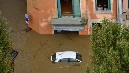 A Trèbes (Aude), une voiture est noyée dans une rue inondée, dans les intempéries du 15 octobre 2018. (SYLVAIN THOMAS / AFP)