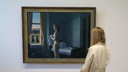 Une femme devant un tableau du peintre à l'exposition "Edward Hopper's New York"au Whitney Museum de Manhattan, le 27 octobre 2022 (TIMOTHY A. CLARY / AFP)