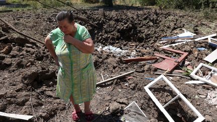 Une dame constate l'étendue des dégâts, le 17 juillet 2022, après un bombardement sur Toretsk (Ukraine). (ANATOLII STEPANOV / AFP)