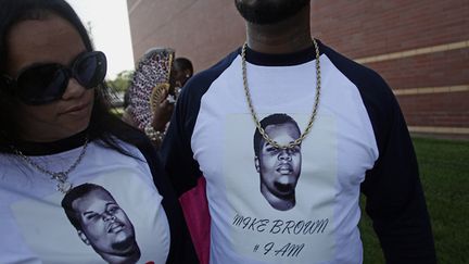 &nbsp; (Deux personnes portant des t-shirts hommage à Michael Brown, devant l'église où doivent avoir lieu les obsèques ce lundi. © REUTERS/Joshua Lott)