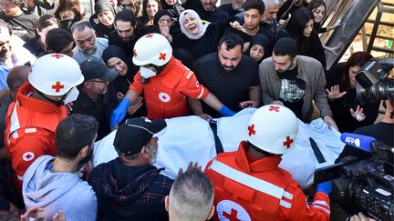 Les proches et les collègues de trois journalistes tués dans une frappe israélienne dans le village libanais de Hasbaya au sud du pays se rassemblent autour d’une ambulance de la Croix-Rouge alors que leurs corps arrivent à l’hôpital de Beyrouth le 25 octobre 2024. (FADEL ITANI / AFP)