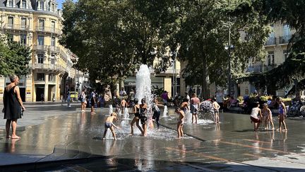 Des enfants se baignent dans une fontaine publique dans le centre ville de Toulouse, mardi 22 août 2023. (REMY GABALDA / MAXPPP)