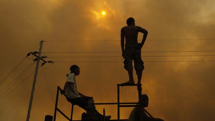 Des ouvriers observent des feux de for&ecirc;t pr&egrave;s de Riau sur l'&icirc;le de Sumatra (Indon&eacute;sie), le 24 juin 2013. (BEAWIHARTA  / REUTERS  )