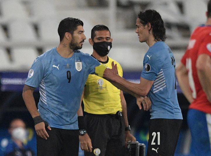 Edinson Cavani donne le bracelet de capitaine à son remplaçant, Luis Suarez, lors de la rencontre de phases de poule face au Paraguay le 28 juin dernier.&nbsp; (CARL DE SOUZA / AFP)