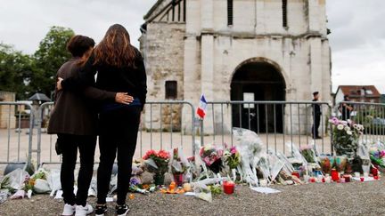 Fleurs et recueillements, le 27 juillet 2016, devant l'église de Saint-Etienne-du-Rouvray, près de Rouen en Normandie, au lendemain de l'égorgement du prêtre Jacques Hamel par deux djihadistes. Un crime aussitôt revendiqué par l'organisation de l'Etat islamique.  (CHARLY TRIBALLEAU/AFP)