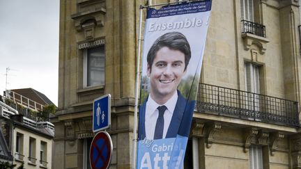 Un drapeau à l'effigie de Gabriel Attal, posé par des militants Renaissance pour le premier tour des élections législatives, à Issy-les-Moulineaux, le 14 juin 2024. (MAGALI COHEN / HANS LUCAS / AFP)