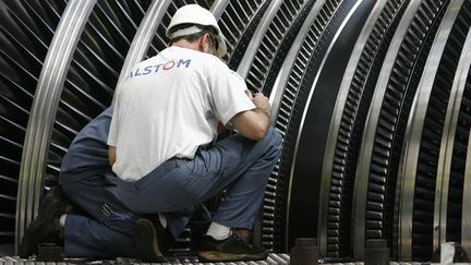 Des salari&eacute;s d'Alstom travaillent sur une pi&egrave;ce de r&eacute;acteur thermique, sur le site de Braud-et-Saint-Louis, le 27 septembre 2006. (JEAN-PIERRE MULLER / AFP)