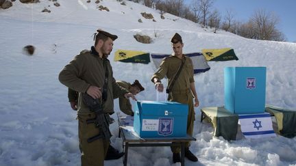 Des militaires israéliens en poste sur le plateau du Golan votent en plein air. (AFP/ Menahem Kanaha)