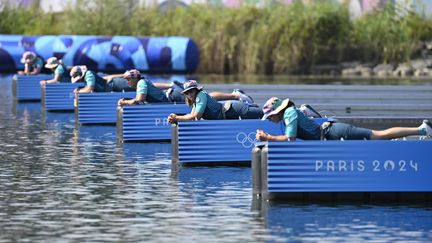 Les volontaires allongés, après le départ des rameurs, le 30 juillet 2024 à Vaires-sur-Marne, lors des Jeux olympiques de Paris 2024. (GROSCLAUDE ALAIN / AFP)