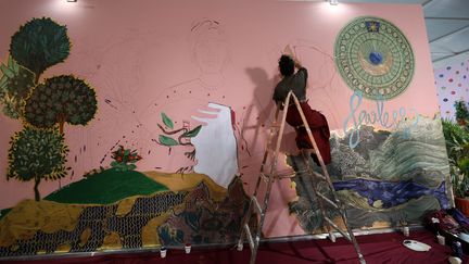 L'artiste Shilo Shiv Suleman peint une fresque intitulée "intrépide" au pavillon de la jeunesse, lors du sommet sur le climat COP27 dans la station balnéaire de la mer Rouge à Charm el-Cheikh, le 12 novembre 2022.&nbsp; (FAYEZ NURELDINE / AFP)