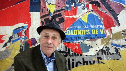 3 septembre&nbsp;2008. Jacques Villeglé, 82 ans, pose devant l'une de ces célèbres affiches lacérées à Paris, au Centre Pompidou. L'artiste français décédé le 7 juin 2022 à 96 ans, membre fondateur du Nouveau Réalisme est considéré par les artistes contemporains du street art comme le pionnier de l'art urbain.&nbsp; (PATRICK KOVARIK / AFP)