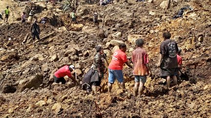 Des habitants du village de Yambali, en Papouasie-Nouvelle-Guinée, tentent de retrouver des survivants, le 30 mai 2024 après un éboulement de terrain. (EMMANUEL ERALIA / AFP)