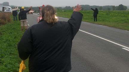  (Au bord de la route, Aurélie salue la caravane pour avoir quelques cadeaux © RF/BS)