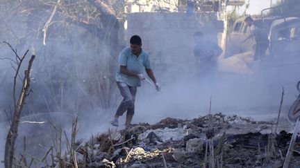 Des Syriens tentent d'éteindre un feu provoqué par un bombardement de l'aviation russe dans la province d'Idlib en Syrie, le 4 septembre 2018.&nbsp; (ZEIN AL RIFAI / AFP)