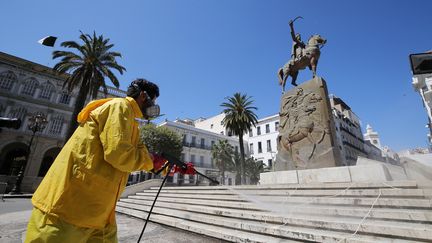 Un travailleur nettoie les rues de&nbsp;d'Alger après l’épidémie de coronavirus (Covid-19), le 30 mars 2020.&nbsp; (BILLAL BENSALEM / NURPHOTO)