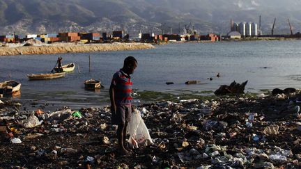 Un garçon regarde les ordures dans le bidonville de Cité Soleil, en Haïti, le 15 mars 2011.   ( REUTERS/Shannon Stapleton)