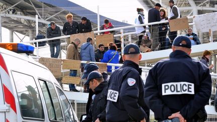 Des policiers font face &agrave; des migrants syriens qui bloquent une passerelle du terminal ferry de Calais (Pas-de-Calais), le 3 octobre 2013. (PHILIPPE HUGUEN / AFP)