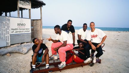 L'équipe jamaïcaine de Bobsleigh, Devon Harris, Dudley Stokes, Michael White, Freddy Powell, et le remplaçant de dernière minute Chris Stokes, photographiés le 2 mai 1991 sur une plage de Kingston. Ils ont participé en 1988 au aux Jeux olympiques de Calgary (Canada). (PAUL HARRIS / ARCHIVE PHOTOS / VIA GETTY IMAGES)