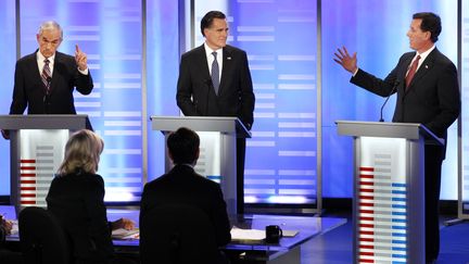 Mitt Romney (au centre) a &eacute;t&eacute; la cible d'attaques de la part de ses adversaires, comme Ron Paul (&agrave; gauche) ou&nbsp;Rick Santorum (&agrave; droite) lors du d&eacute;bat organis&eacute; dans le New Hampshire le 7 janvier 2012. (MIKE SEGAR /&nbsp;REUTERS)