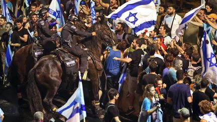 Des manifestants se heurtent à la police anti-émeute israélienne lors d'une manifestation contre le plan de réforme judiciaire du gouvernement, à Tel-Aviv, le 24 juillet 2023. (JACK GUEZ / AFP)