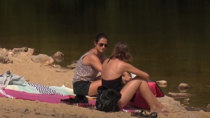 Des touristes profitent d'une toute petite plage à Saint-Cirq-Lapopie, dans le Lot. (France 3)