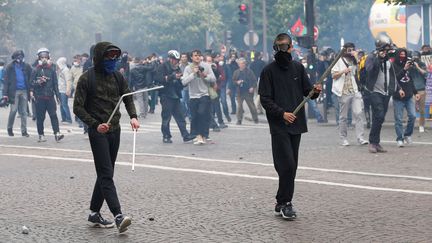 Des manifestants armés de bâtons font face aux forces de l'ordre, le 17 mai 2016 place Denfert-Rochereau à Paris, lors d'une manifestation contre la loi Travail. (THOMAS SAMSON / AFP)