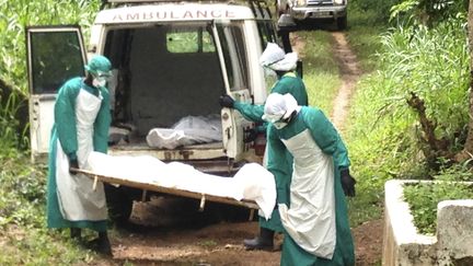 Des employ&eacute;s d'un h&ocirc;pital transportant des malades morts de l'&eacute;pid&eacute;mie de virus Ebola, le 25 juin 2014, &agrave; Kenema (Sierra Leone). ( JNA / REUTERS)