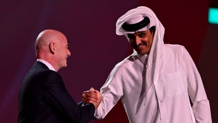 L'émir du Qatar, Tamim Ben Hamad Al Thani, salue le président de la&nbsp;FIFA,&nbsp;Gianni Infantino, à l'occasion du tirage au sort de la Coupe du monde, le 1er avril 2022 à Doha (Qatar). (FRANCOIS-XAVIER MARIT / AFP)