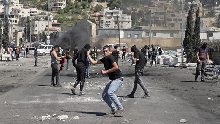 Des manifestants palestiniens affrontent les forces de sécurité israéliennes, dans le village de Beita, en Cisjordanie occupée, le 15 avril 2022. (JAAFAR ASHTIYEH / AFP)