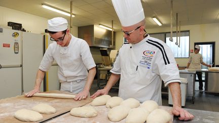 Un apprenti boulanger (à gauche) et son professeur (à droite) au Centre de formation des Apprentis (CFA) de Quimper (Finistère). (FRED TANNEAU / AFP)