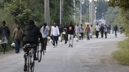 Des migrants marchent dans la rue &agrave; proximit&eacute; de la nouvelle jungle de Calais (Pas-de-Calais), un camp de fortune, le 19 ao&ucirc;t 2015.&nbsp; (REGIS DUVIGNAU / REUTERS)