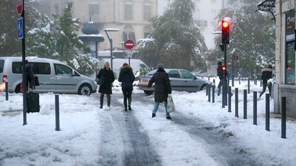 Des habitants de Valence (Drôme) marchent dans la neige, le 14 novembre 2019. (NICOLAS GUYONNET / HANS LUCAS / AFP)