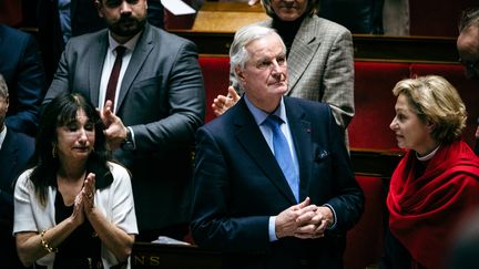 Le Premier ministre Michel Barnier applaudi après son discours contre les motions de censure visant son gouvernement, à l'Assemblée nationale, le 4 décembre 2024. (AMAURY CORNU / HANS LUCAS / AFP)