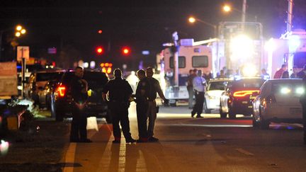 Des policiers bloquent l'accès au lycée Marjory Stoneman Douglas, à Parkland (Floride, Etats-Unis), où un tireur a tué 17 personnes, le 14 février 2018. (GASTON DE CARDENAS / AFP)