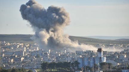 De la fum&eacute;e au-dessus de Kobani (Syrie), apr&egrave;s des frappes de la coalition men&eacute;e par les Etats-Unis, le 23 d&eacute;cembre 2014. (RAUF MALTAS / ANADOLU AGENCY / AFP)