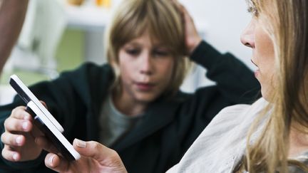 &nbsp; (Le téléphone portable, un moyen pour beaucoup de parents d'avoir un oeil sur leurs enfants © MaxPPP)