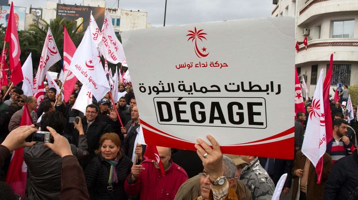 Un homme brandit une pancarte destin&eacute;e au gouvernement sur laquelle est &eacute;crit "d&eacute;gage", lors d'une manifestation &agrave; Tunis (Tunisie) le 14 janvier 2013. Deux ans apr&egrave;s la "r&eacute;volution de jasmin", les Tunisiens font toujours face &agrave; un fort taux de ch&ocirc;mage.&nbsp; (AMINE LANDOULSI / AP / SIPA)