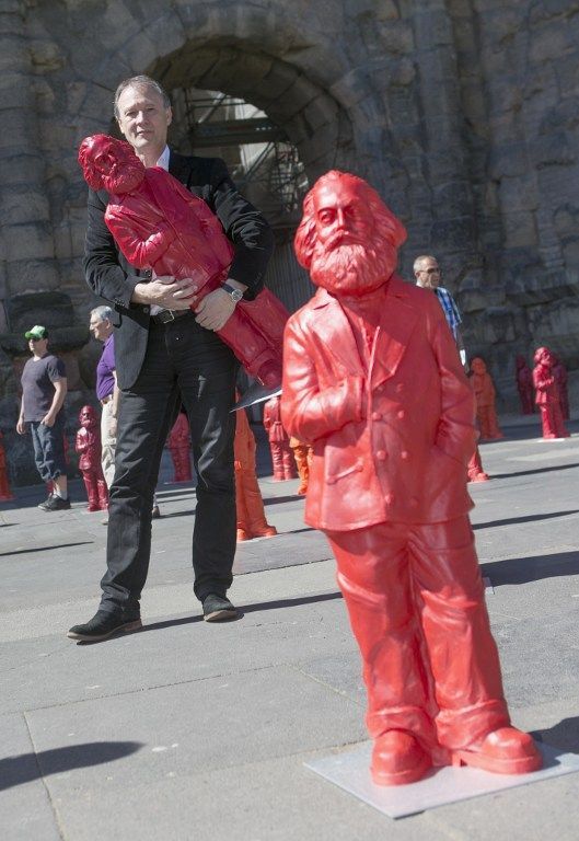 L'artiste allemand Ottmar Hoerl pose avec une des statues de Karl Marx. Il a installé 500 statues pour le 195e anniversaire de cette figure du communisme
 (THOMAS WIECK / AFP)