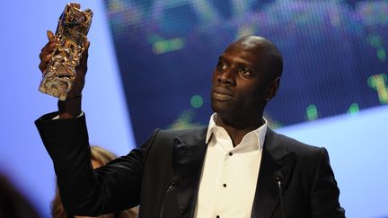 Omar Sy brandit son César du meilleur acteur pour son rôle dans "Intouchables" le 24 février 2010 à Paris, lors de la 37e cérémonie des César. (ERIC FEFERBERG / AFP)