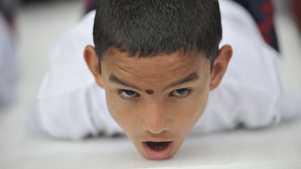 A Katmandou (capitale du Népal), un enfant effectue une position du yoga dans un ashram tenu par un gourou -un maître - indien. (NARAYAN MAHARJAN / NURPHOTO)