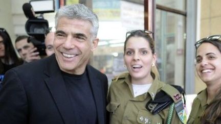 Yaïr Lapid avec deux soldates israéliennes. (David Buimovitch / AFP)