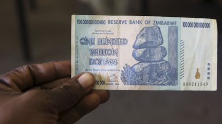 Un billet de 100 000 milliards de dollars zimbabwéens. Victime de l'hyperinflation, la monnaie du Zimbabwe a-t-elle encore un avenir ? (PHILIMON BULAWAYO / Reuters)