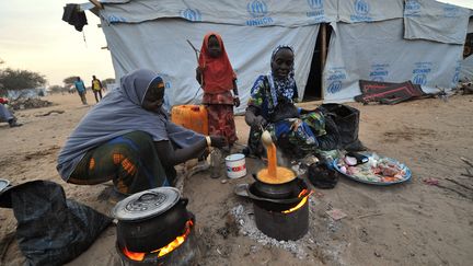 Des Nig&eacute;rianes cuisinent dans un camp de r&eacute;fugi&eacute;s sur les rives du lac Tchad, le 26 janvier 2015.&nbsp; (SIA KAMBOU / AFP)