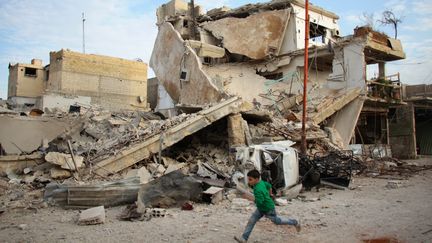 Un enfant syrien court durant un bombardement du régime de Bachar al-Assad, le 20 février 2018. (HAMZA AL-AJWEH / AFP)