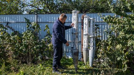 Un paysan ukrainien expose des roquettes à sous-munitions découvertes dans son champ dans l'oblast de Kherson, le 16 octobre 2022. (VIRGINIE NGUYEN HOANG / HANS LUCAS / AFP)